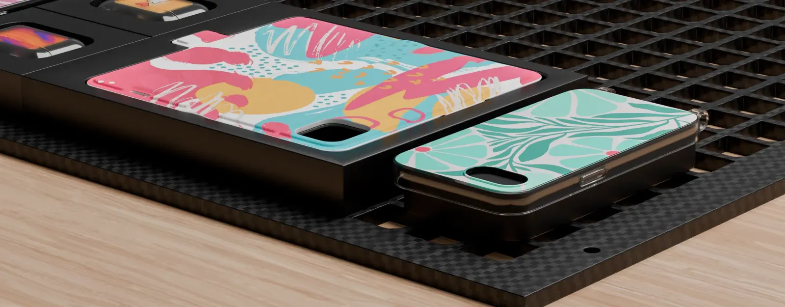 Phone cases on a print bed, one printed with a colorful pattern